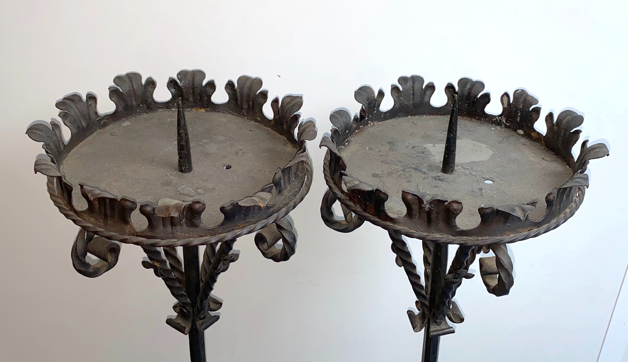 A pair of wrought iron Prickett lamp standard candlesticks, in the 18th century manner, height 157cm. width of base 38cm.